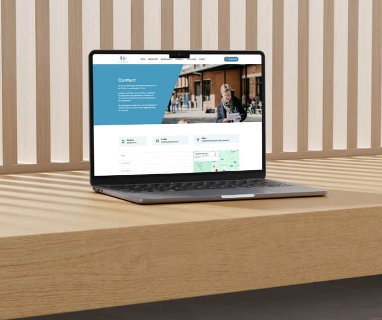 Laptop met contactpagina van Instituut Heilig Hart, onderwijsinstelling in een moderne omgeving.